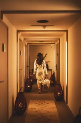 a woman walking down a hallway in a room at Les Lodges Sainte-Victoire Hotel & Spa in Aix-en-Provence