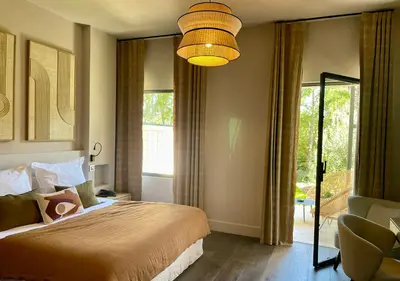 a bedroom with a bed and a large window at Les Lodges Sainte-Victoire Hotel & Spa in Aix-en-Provence