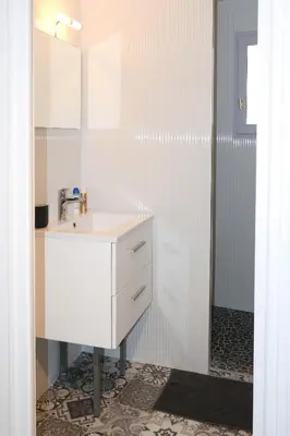 a white bathroom with a sink and a mirror at ROGERIO en PLEIN CENTRE DE L'ISLE SUR SORGUE in LʼIsle-sur-la-Sorgue