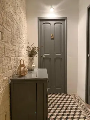 a hallway with a green door and a tile floor at Bastide Sainte Agnès in Carpentras