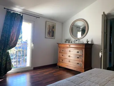 a bedroom with a dresser and a mirror and a window at Bastide Sainte Agnès in Carpentras