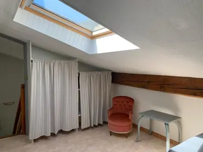 a room with a skylight and a chair and a table at Gîte les Cyprès (Bastide Sainte Agnès) in Carpentras