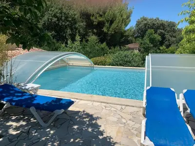 a swimming pool with two chairs and a swimming poolvisor at Gîte les Cyprès (Bastide Sainte Agnès) in Carpentras