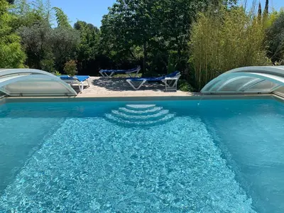 a pool of blue water with two chairs in it at Gîte L'Olivier (Bastide Sainte Agnès) in Carpentras