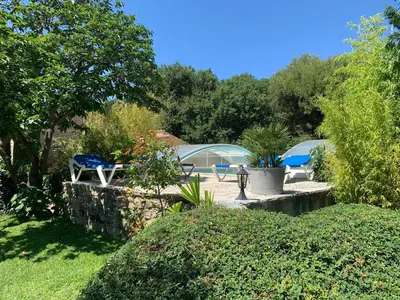 a garden with two chairs and a tent at Gîte L'Olivier (Bastide Sainte Agnès) in Carpentras