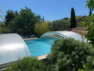 a swimming pool in a yard with a house at Gîte L'Olivier (Bastide Sainte Agnès) in Carpentras
