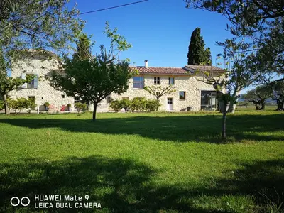 a large stone house with trees in front of it at DOMAINE de MAS CARON Gîte 4* au pied du Ventoux en Provence in Caromb