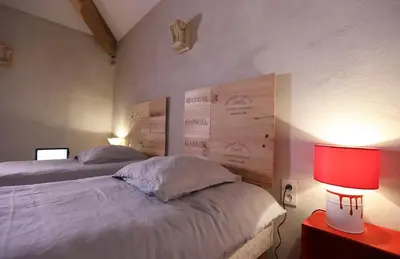 a bedroom with two beds and a red lamp at DOMAINE de MAS CARON Gîte 4* au pied du Ventoux en Provence in Caromb