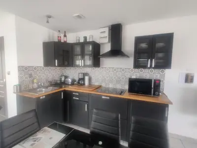 a kitchen with black cabinets and a microwave at Gîte du Charme Provençal in Sénas