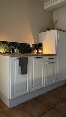 a kitchen with white cabinets and a counter top at Une Pause Douceur - Suite Orchidée in Eyguières