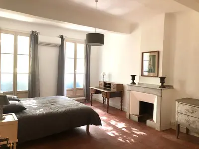 a bedroom with a bed and a desk and a fireplace at Beau 3 pièces 83 m2 au coeur du centre historique d'Aix en Provence in Aix-en-Provence