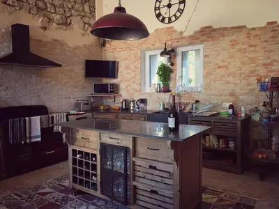a kitchen with a counter and a clock on the wall at Mas de L Angeos in Velleron