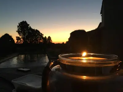 a candle in a tea pot with the sunset in the background at Mas de L Angeos in Velleron
