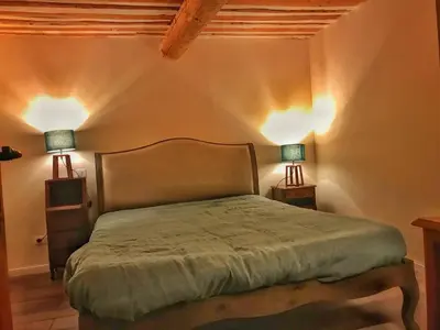a bedroom with a bed with two lamps on it at Mas de L Angeos in Velleron
