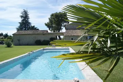 a swimming pool in the yard of a house at B&B dans Mas en pierres in Robion en Luberon