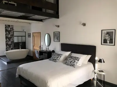 a bedroom with a large bed and a bath tub at B&B dans Mas en pierres in Robion en Luberon