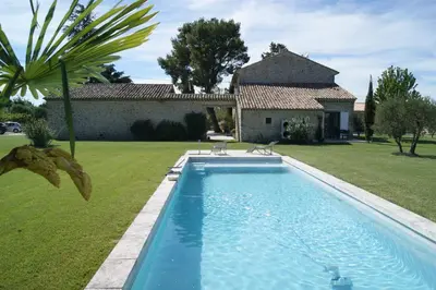 a swimming pool in a yard with a house at B&B dans Mas en pierres in Robion en Luberon
