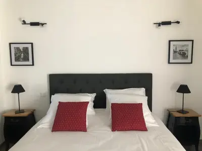 a bedroom with a bed with two red pillows at B&B dans Mas en pierres in Robion en Luberon