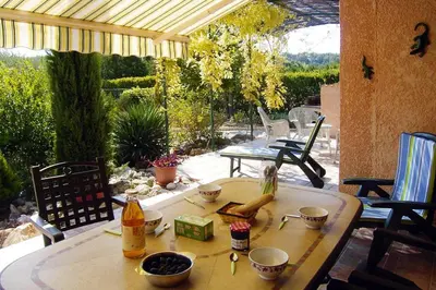 a table with a doll sitting on it on a patio at Holiday Home near Mont Ventoux Ski Resort in Bédoin