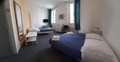 a hotel room with two beds and a mirror at Hôtel Du Cours in Pertuis
