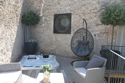 a patio with two chairs and a table and a swing at Loft avec spa Lourmarin in Lourmarin