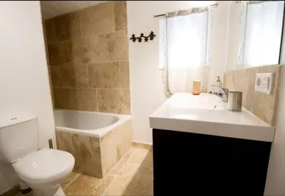 a bathroom with a toilet and a sink and a tub at Chambre d'hôte Geiko in Cabrières-dʼAigues