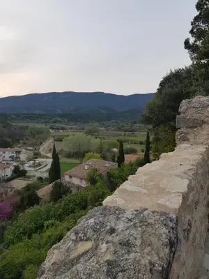 a stone wall with a view of a town at Chambre d'hôte Geiko in Cabrières-dʼAigues