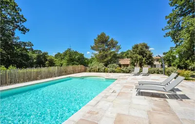 a swimming pool with chairs and a fence at Awesome Home In Saint-Rémy-De-Provence in Saint-Rémy-de-Provence