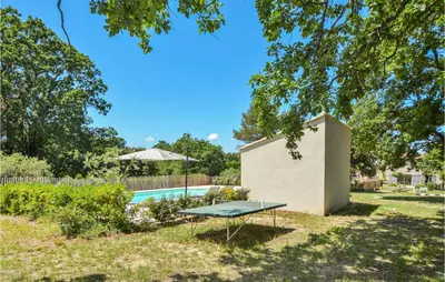 a picnic table in the grass next to a pool at Awesome Home In Saint-Rémy-De-Provence in Saint-Rémy-de-Provence