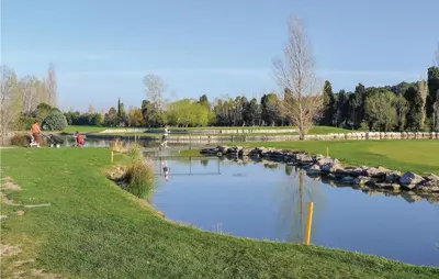 a pond in a park with people standing around it at Awesome Home In Saint-Rémy-De-Provence in Saint-Rémy-de-Provence
