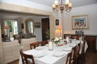 a dining room with a table and a living room at Mas de Michel in Bonnieux