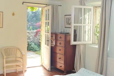 a bedroom with a dresser and an open door at Mas de Michel in Bonnieux