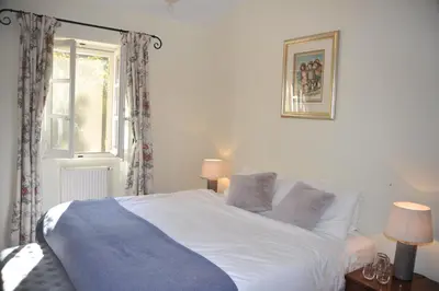 a white bed in a bedroom with a window at Mas de Michel in Bonnieux