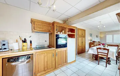 a kitchen with wooden cabinets and a dining room with a table at 2 Bedroom Gorgeous Apartment In Caromb in Caromb