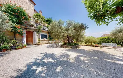 a courtyard of a house with a tree and a bench at 2 Bedroom Gorgeous Apartment In Caromb in Caromb