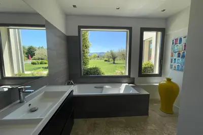 a large bathroom with a large tub and two windows at Mas de Panière - Saint Remy de Provence in Paluds de Noves
