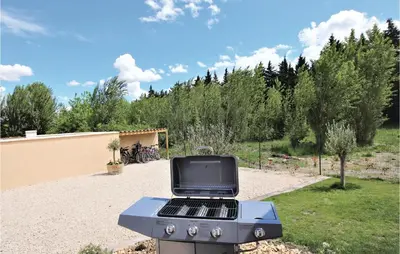 a blue barbecue grill in a yard with trees at Stunning Home In Monteux in Monteux