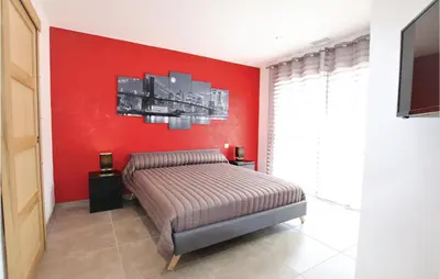 a bedroom with a red wall and a bed at Stunning Home In Monteux in Monteux