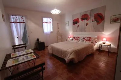 a bedroom with a bed and two tables and two windows at CLOS DE LA FONT in Mollégès