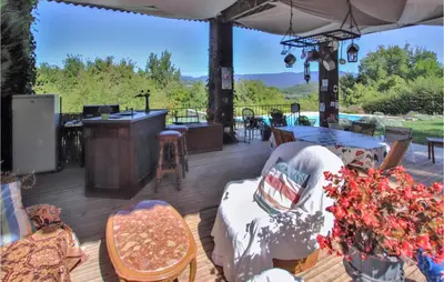 a deck with chairs and tables and a bar at Stunning Home In Saignon in Saignon