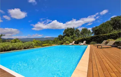 a swimming pool with two chairs on a wooden deck at Stunning Home In Saignon in Saignon