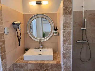 a bathroom with a sink and a mirror at Logis Hotel le Mas De Cure Bourse in LʼIsle-sur-la-Sorgue