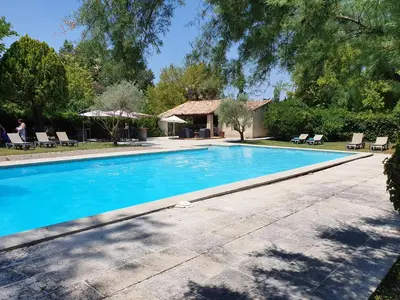 a swimming pool in front of a house at Logis Hotel le Mas De Cure Bourse in LʼIsle-sur-la-Sorgue
