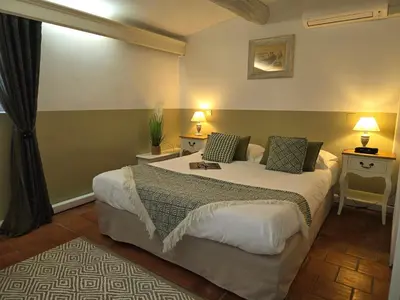 a bedroom with a bed and two tables and two lamps at Logis Hotel le Mas De Cure Bourse in LʼIsle-sur-la-Sorgue