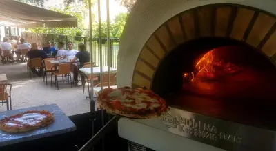 a pizza is being cooked in a pizza oven at Logis Hôtel Restaurant du Parc in Fontaine-de-Vaucluse