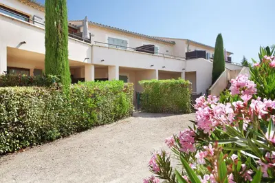 a building with pink flowers in front of it at Résidence Odalys Les Soleils du Luberon in Bonnieux