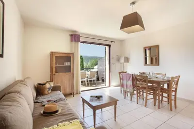 a living room with a couch and a table at Résidence Odalys Les Soleils du Luberon in Bonnieux