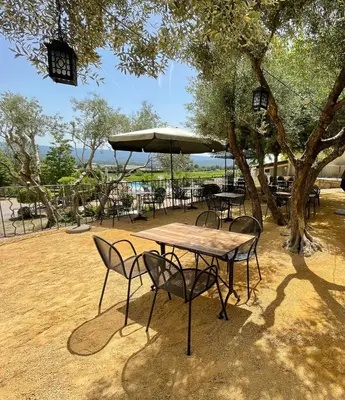 a restaurant with tables and chairs and a bar at Vilajoun in Joucas