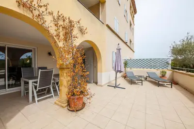 a patio with chairs and a table and an umbrella at Le Cigalou in Mallemort