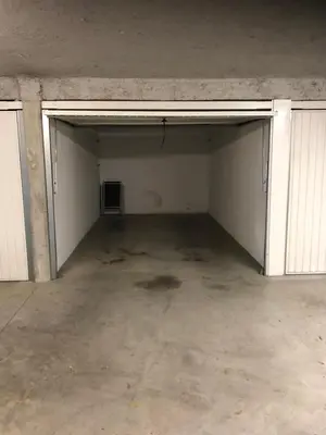 an empty garage with white doors and a room at Le Cigalou in Mallemort